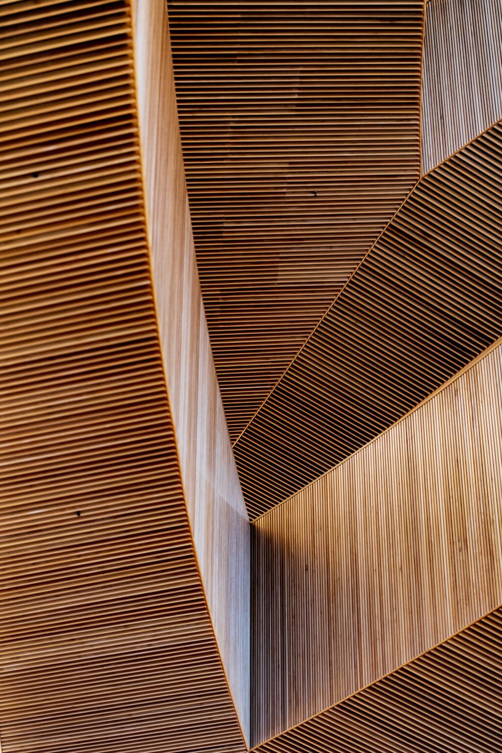 Détail d'un plafond et de murs en lames de bois alignées, aux lignes géométriques